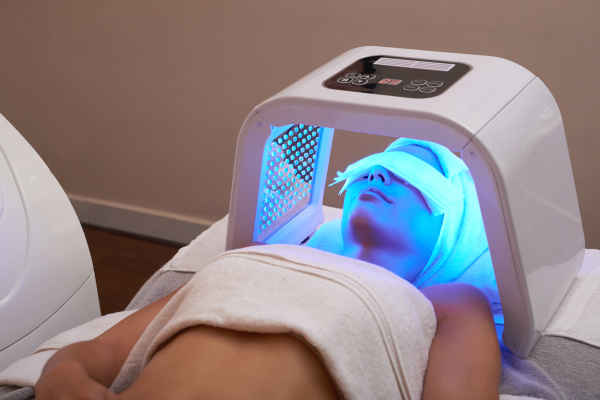 woman getting a LED light treatment on her face to rejuvenate her skin